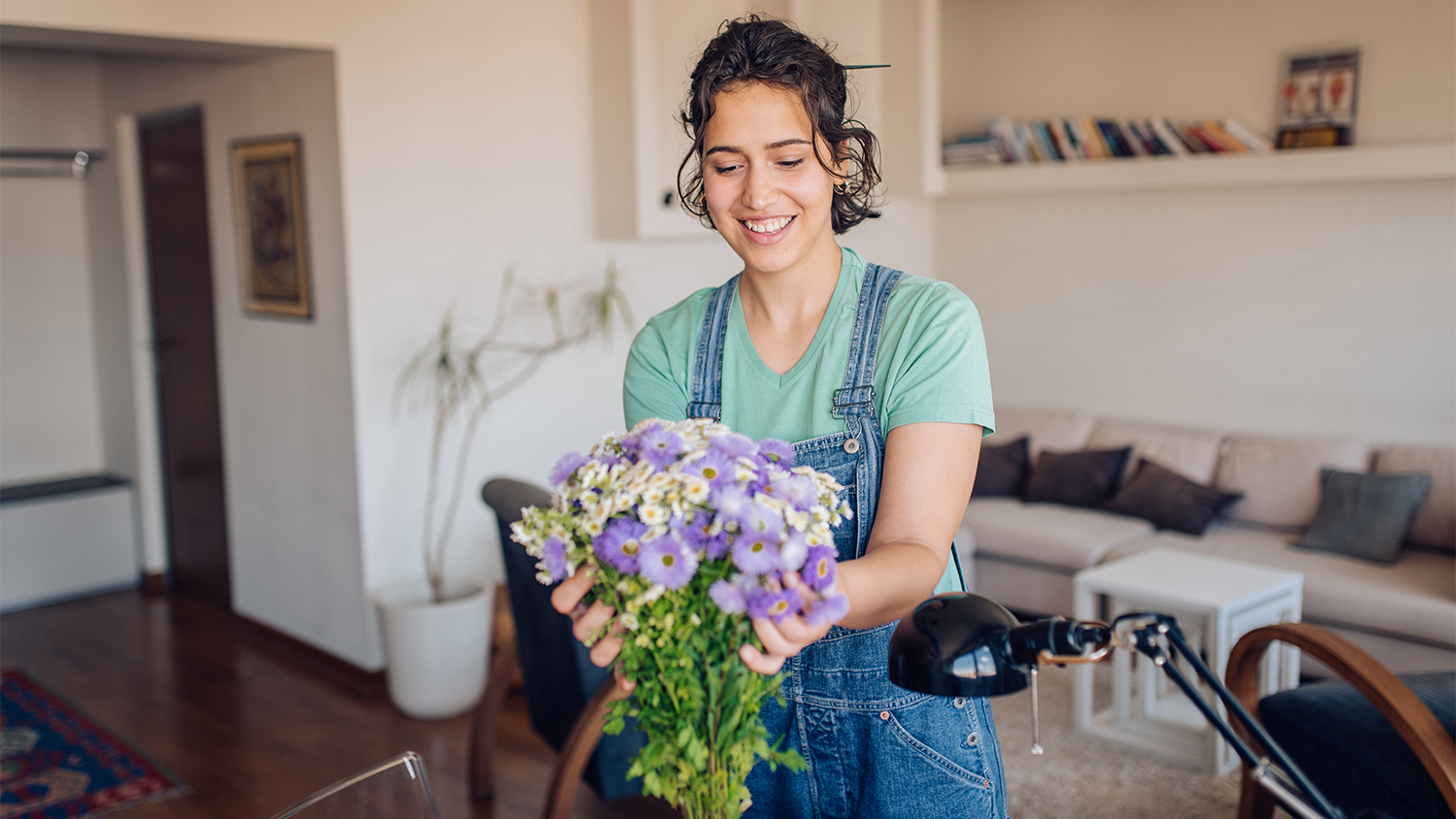 woman putting out flowers in apartment 
